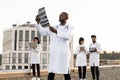 African doctor holding x-ray scan of patient during break outdoors hospital. Royalty Free Stock Photo