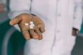 African doctor or pharmacist holding pill, male hand with medication close-up. Man with tablet, concept of pharmacist Royalty Free Stock Photo