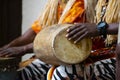 A African Drummer playing on a drum in day time.