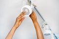 Electrician african man worker installing a ceiling LED spotlight