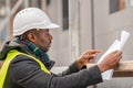 African engineer checking office blueprints on construction site Royalty Free Stock Photo