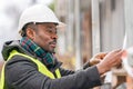 African engineer checking office blueprints on construction site Royalty Free Stock Photo