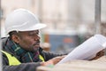 African engineer checking office blueprints on construction site Royalty Free Stock Photo