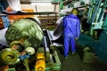 African factory worker checking a roll of rubber on a machine in a conveyor belt factory