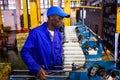 African factory worker on a copwinder weft assembly line loom