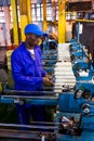 African factory worker on a copwinder weft assembly line loom