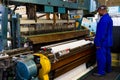 African factory worker operating a cotton thread weft loom machine