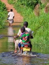 African family crossing river on a motorbike in Uganda