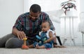 African family, happy father and little cute daughter toddler baby playing blocks toy and sitting on floor together at home Royalty Free Stock Photo