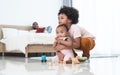 African family, little boy holding cute newborn baby girl, brother and sister playing wooden blocks toy and xylophone together on Royalty Free Stock Photo