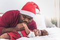 Father wearing a red Christmas hat and kissing hand  his 4-month-old baby newborn son Royalty Free Stock Photo