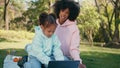 African family relaxing tablet in green park close up. Daughter focused on tab Royalty Free Stock Photo