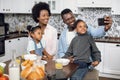 African family using mobile during breakfast on kitchen Royalty Free Stock Photo