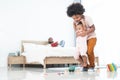 African family, 5 years old boy holding cute newborn 11 months baby girl, brother and sister playing car model toy, wooden blocks Royalty Free Stock Photo