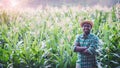 African Farmer with hat stand in the corn plantation field