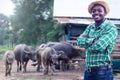 African Farmer with hat stand in the water buffalo farm.Agriculture or cultivation concept Royalty Free Stock Photo