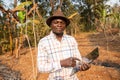 An african farmer in his field with a tablet in his hand, technology in agriculture in Africa