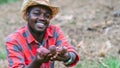 African farmer man holding fresh sweet potato at organic farm.Agriculture or cultivation concept Royalty Free Stock Photo