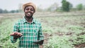 African farmer man holding fresh sweet potato at organic farm with using tablet.Agriculture or cultivation concept Royalty Free Stock Photo