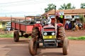 African farmers from rural Tanzania, driving a tractor-trailer.