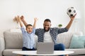 African Father And Son Watching Soccer Online At Laptop Indoors Royalty Free Stock Photo