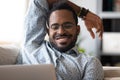 African fellow resting lying on couch using computer watching movie Royalty Free Stock Photo