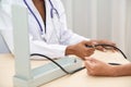 African female Doctor measuring Caucasian male patient blood with pressure Measuring. Royalty Free Stock Photo