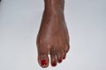 African female foot with red nail varnish Royalty Free Stock Photo