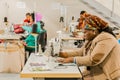 African female seamstresses working on hand-made garments using a sewing machine