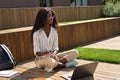 African female student elearning using laptop studying outside campus. Royalty Free Stock Photo