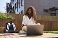 African female student writing notes elearning using laptop studying outside. Royalty Free Stock Photo