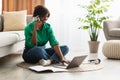 African Female Talking On Mobile Phone Using Laptop At Home Royalty Free Stock Photo