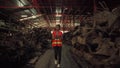 African female worker American inspections inside an old auto parts warehouse.