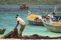 African fisherman catches fishing nets and looks out to sea at sunny day Royalty Free Stock Photo