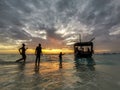 African fishermen on a wooden boat swim up to the shore. Sunset Royalty Free Stock Photo