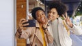 African, friends and happy selfie in city with phone for photography and memory on social media. Peace, sign and women Royalty Free Stock Photo