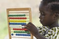 African girl counting on abacus in school