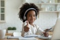 African girl in headphones enjoy showing thumbs up e-learning