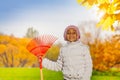 African girl holding red rake in the autumn park