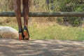 African girl legs with fashion shoes, vegetation in background.