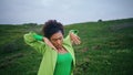 African girl performing modern dance on green field close up. Performer dancing