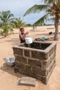 An African girl picks up water from a well