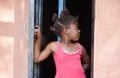 african girl with ponytails standing in the door frame