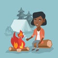 African girl roasting marshmallow over campfire.
