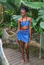 African girl stands on wooden bridge in jungle