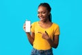 African Girl Showing Mobile Phone Empty Screen Over Blue Background