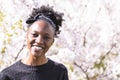 African girl smiles on background of flowering tree Royalty Free Stock Photo