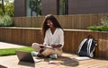 African girl student learning online using laptop studying outside campus. Royalty Free Stock Photo