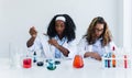 African girl students and Caucasian friends learning experiment research biology and chemical with colorful liquid in tube and Royalty Free Stock Photo