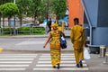 African girl and young man in bright yellow national clothes with bags go after shopping along the street. Dnepropetrovsk
